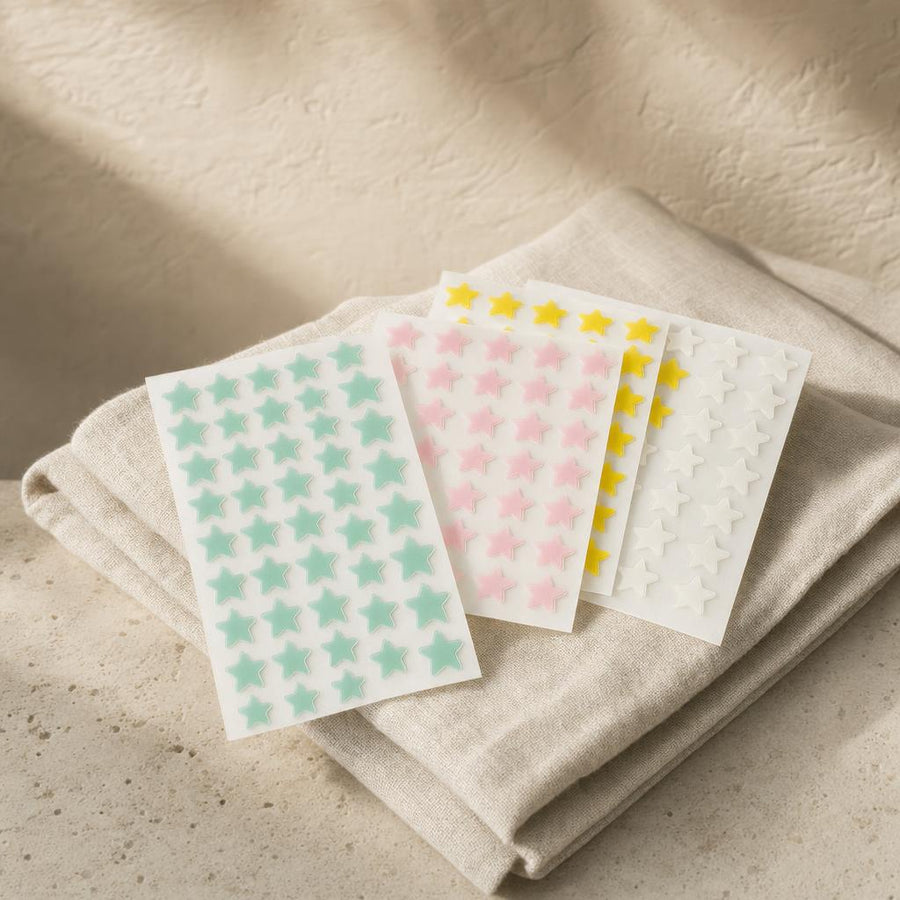 Star-shaped hydrocolloid blemish patches in pastel colors